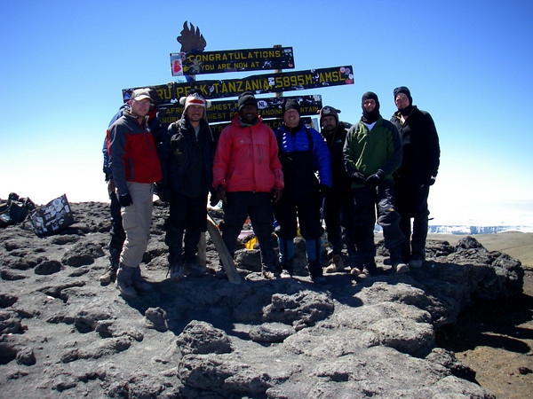 Joe Stewart celebrating his 50th birthday with his son and son-in-laws and Kiliwariors guide team #1 on Mt Kilimanjaro Africa L-to-R Josh (son-in-law), Patrick (commercial jet pilot from Dubai), Faraja (lead guide), Joe, George (dentist from Nova Scotia),